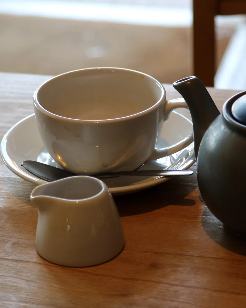 Symbolbild: Teekanne mit Tasse und Milchkännchen